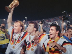 Lothar Matthäus, Andreas Brehme y Pierre Littbarski celebrando con el trofeo de la Copa del Mundo de Italia 1990.